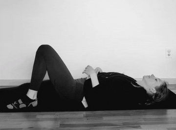A woman doing a hamstring stretch while lying on her back.