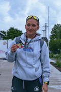Paula Sierzega at a triathlon race holding a medal.