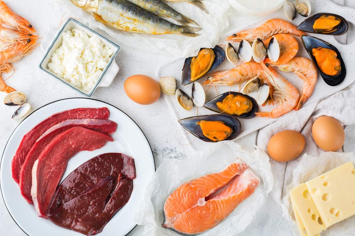 A variety of foods rich in Vitamin B12 like seafood, eggs, cheese, yogurt, and beef.