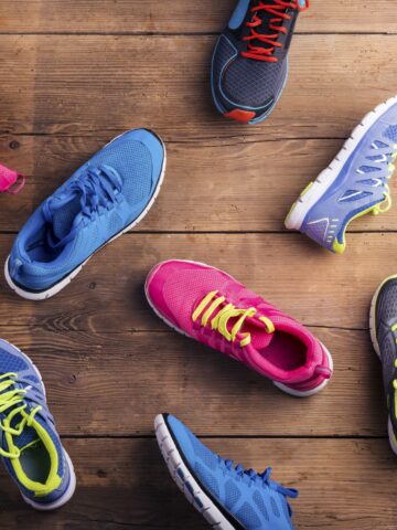 An assortment of running sneakers on a wooden floor.