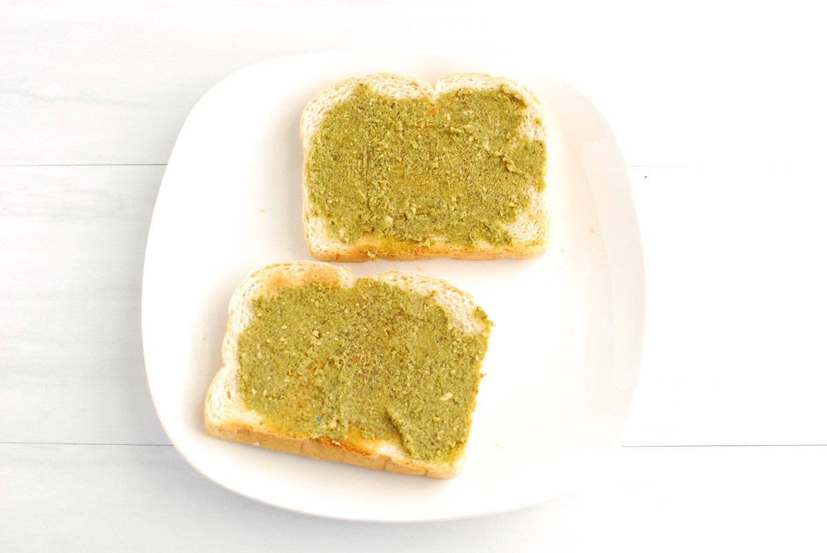 Two slices of toast with pesto on top.