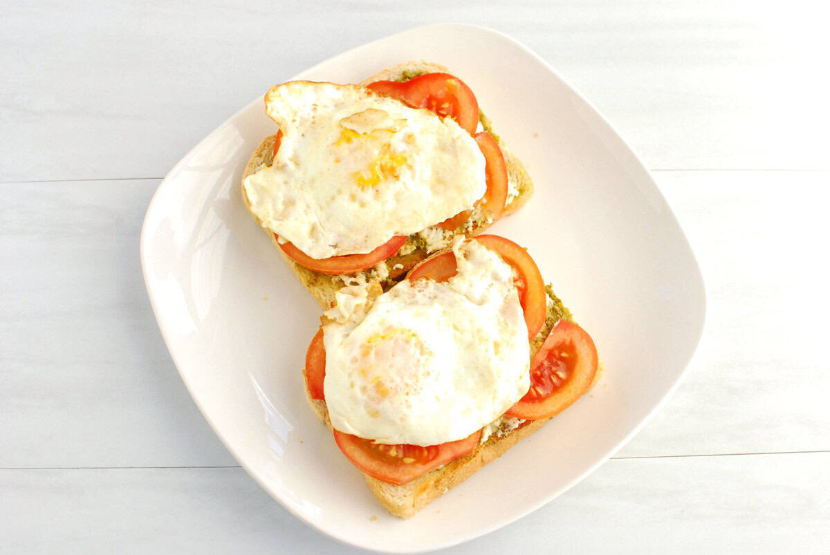 Fried eggs added on top of the pesto burrata toast.