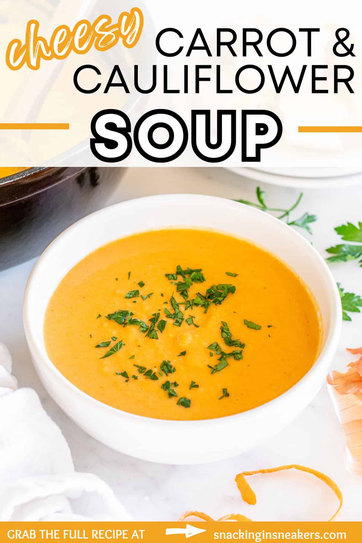 A white bowl filled with cheesy curry carrot cauliflower soup, with a text overlay with the name of the recipe.