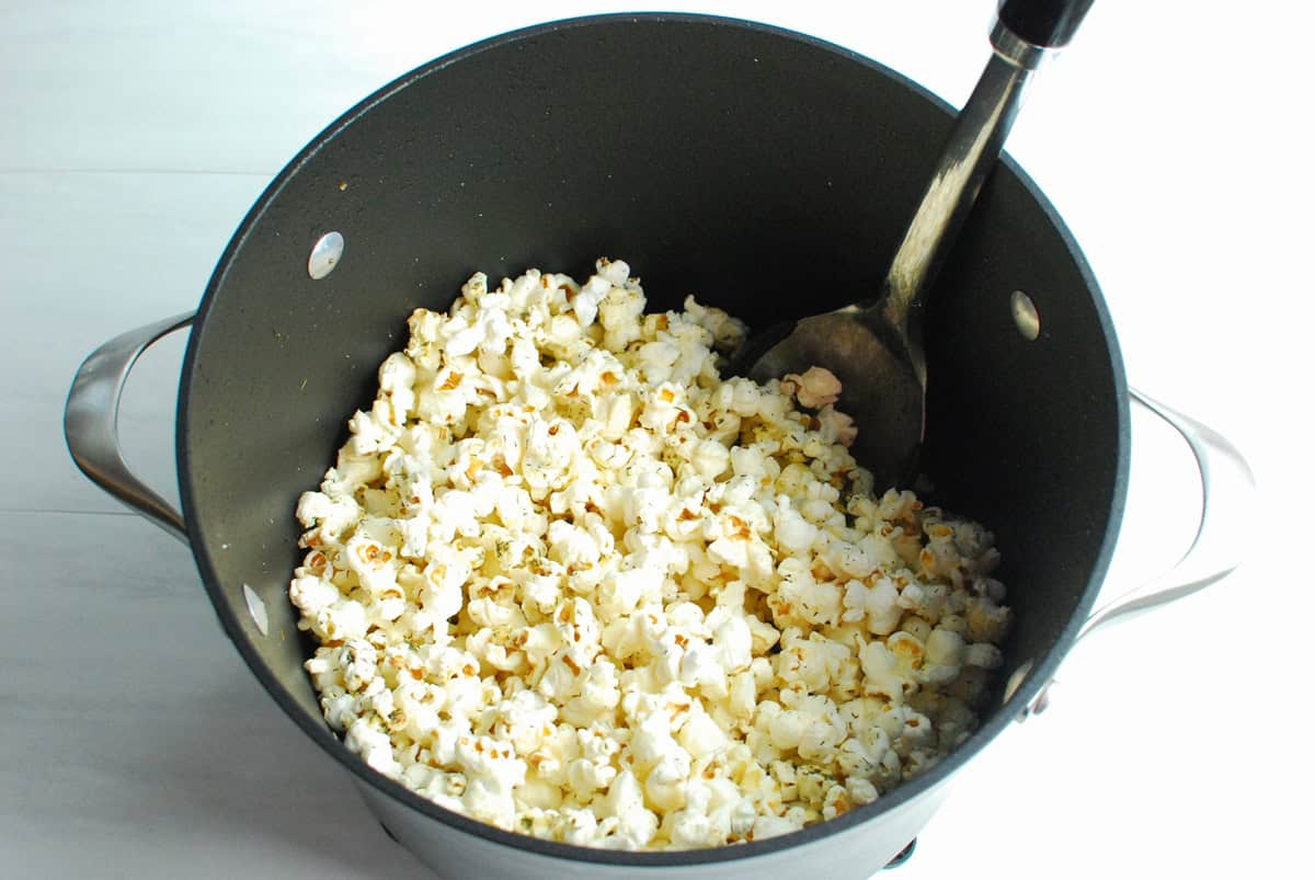 A pot with dill pickle popcorn that has just been popped.