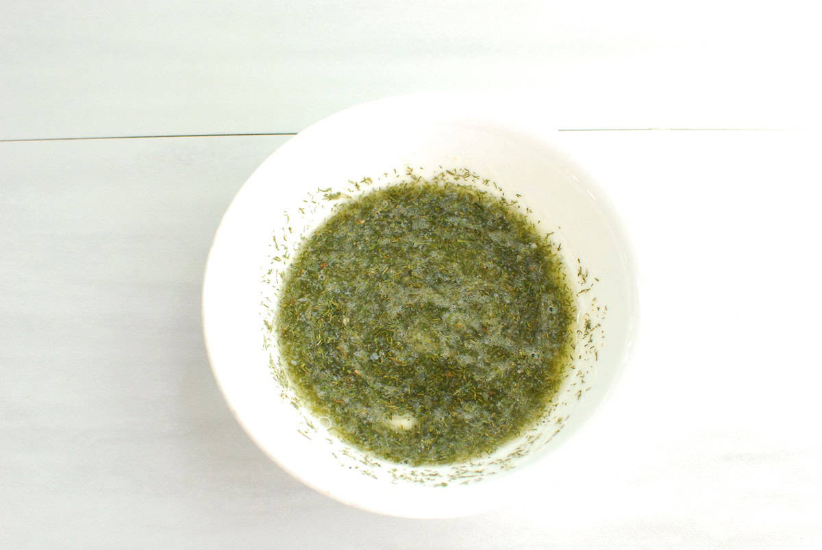 Melted butter, vinegar, and seasonings mixed together in a small bowl.