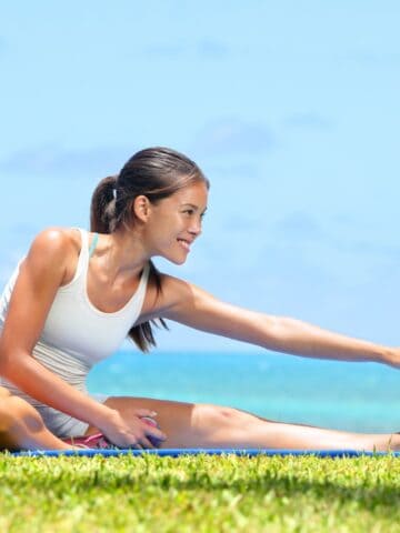 A woman doing a hamstring stretch outside after a run.