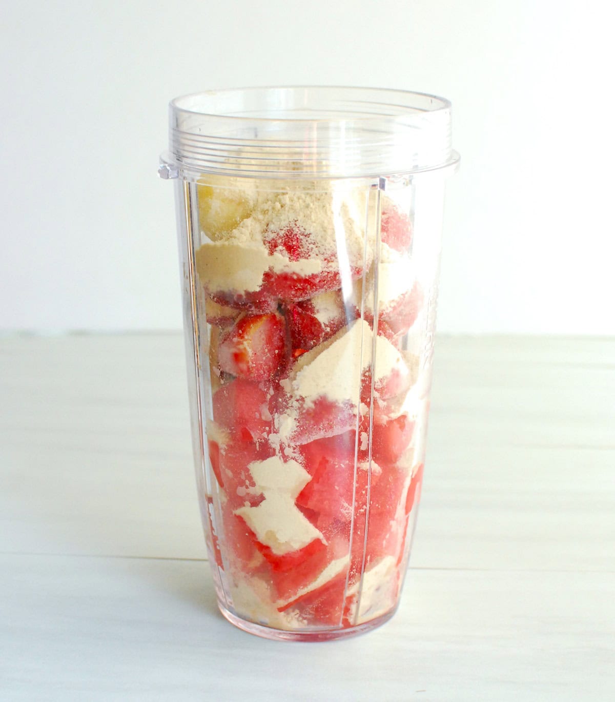 All of the ingredients for a smoothie in a blender cup, before blending.