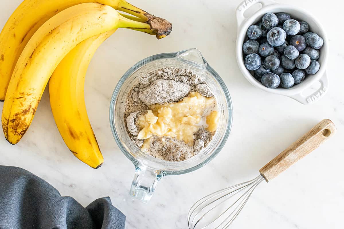 A glass bowl with mashed banana, buckwheat flour, and almond milk.