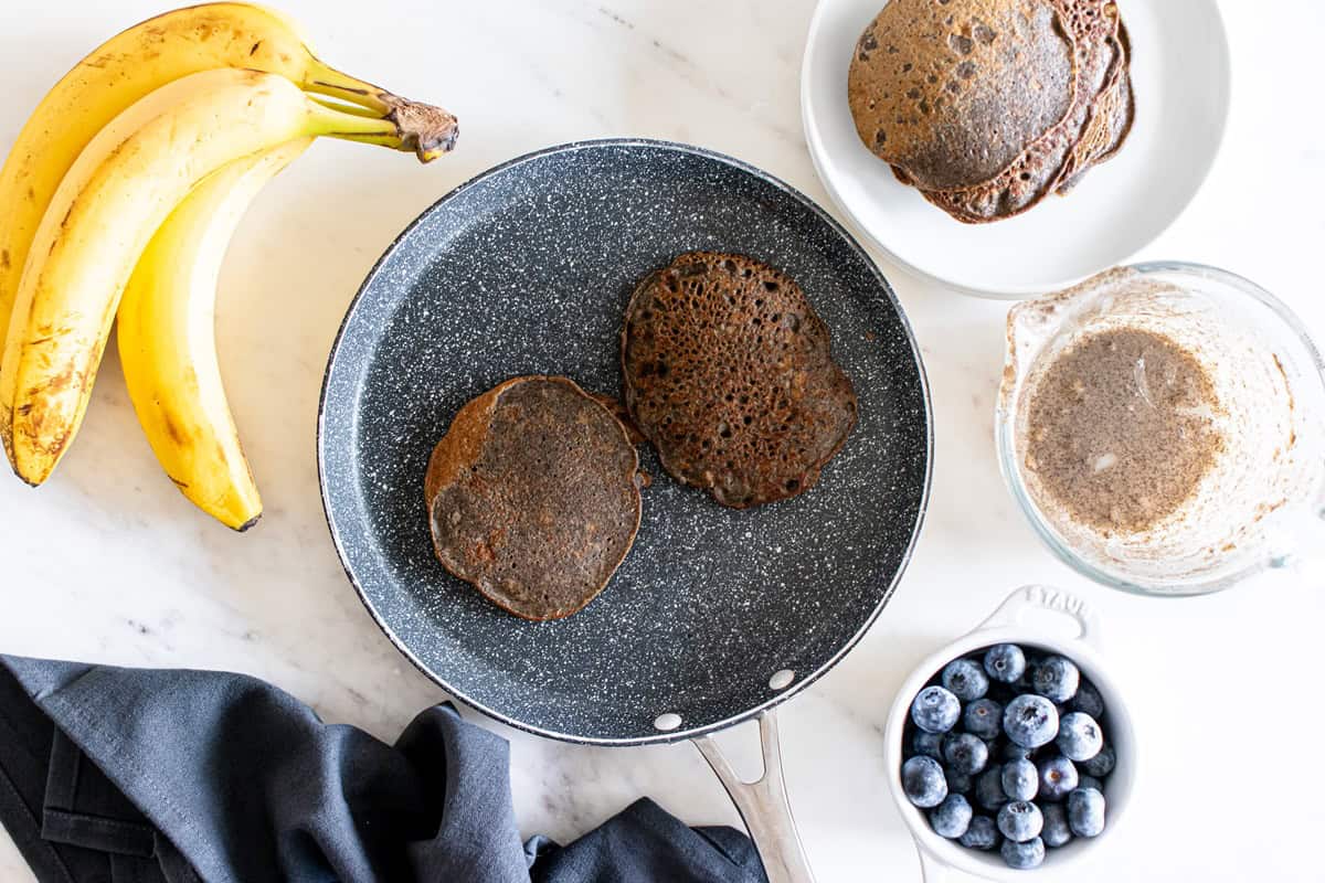 Pancakes cooking in a skillet.
