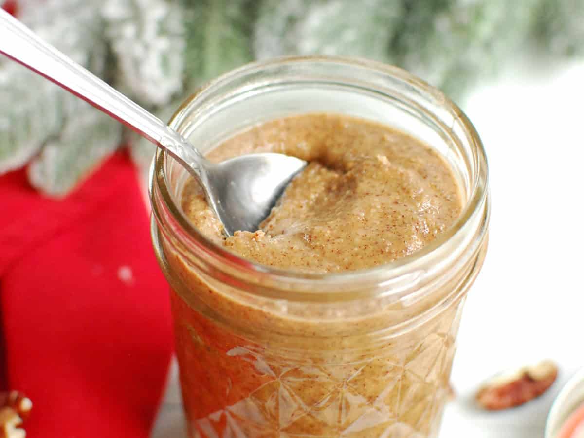 A spoon in a jar of maple macadamia pecan butter.