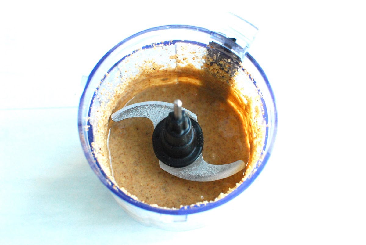 Macadamia pecan butter in a small food processor after 2 minutes of blending, looking creamy.
