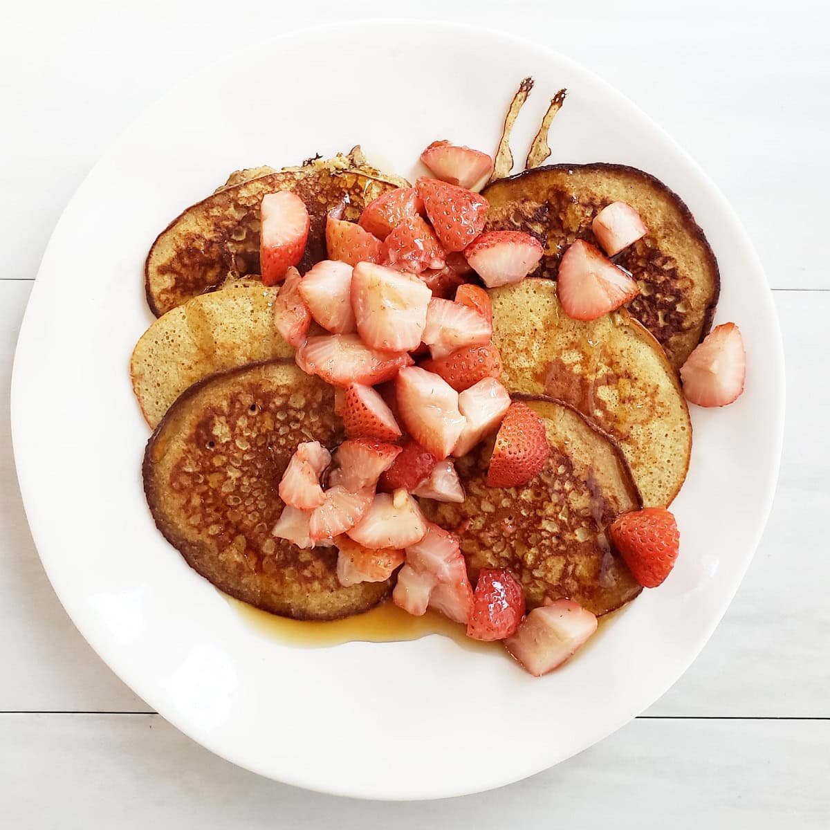 Banana oat pancakes topped with strawberries.