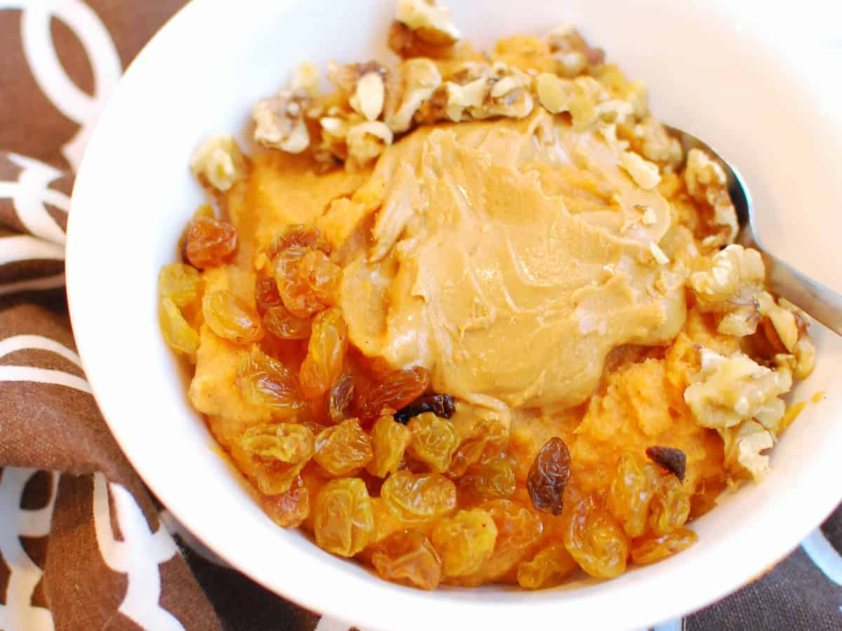 Mashed sweet potato topped with peanut butter and raisins.