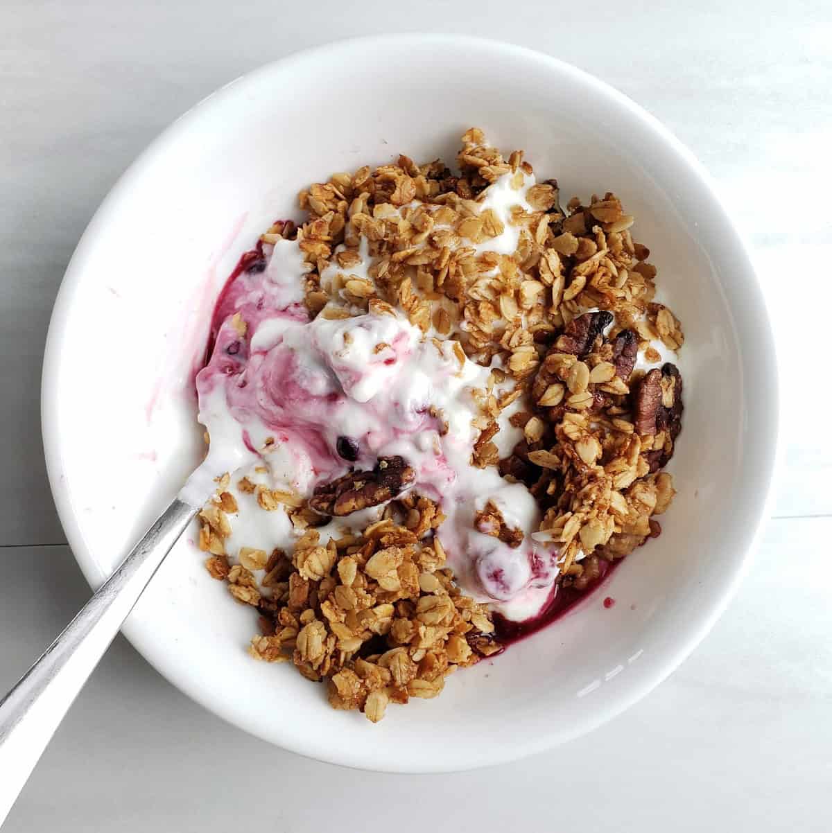 A bowl of yogurt with fruit and granola.