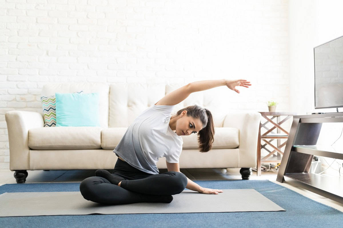 A woman doing yoga at home in her living room.