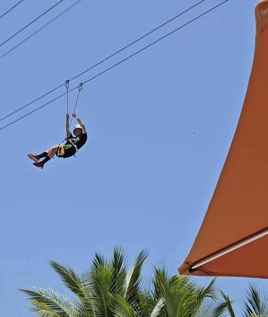 A child zip lining in Amber Cove.