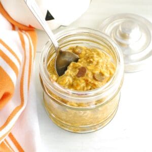 A jar filled with pumpkin protein overnight oats topped with a few chocolate chips.