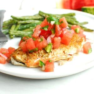 A piece of roasted salmon with watermelon salsa on top.
