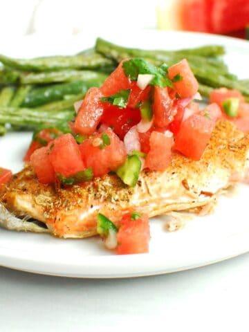 A piece of roasted salmon with watermelon salsa on top.