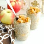 A small mason jar filled with apple pie chia pudding, with a spoon in the jar.
