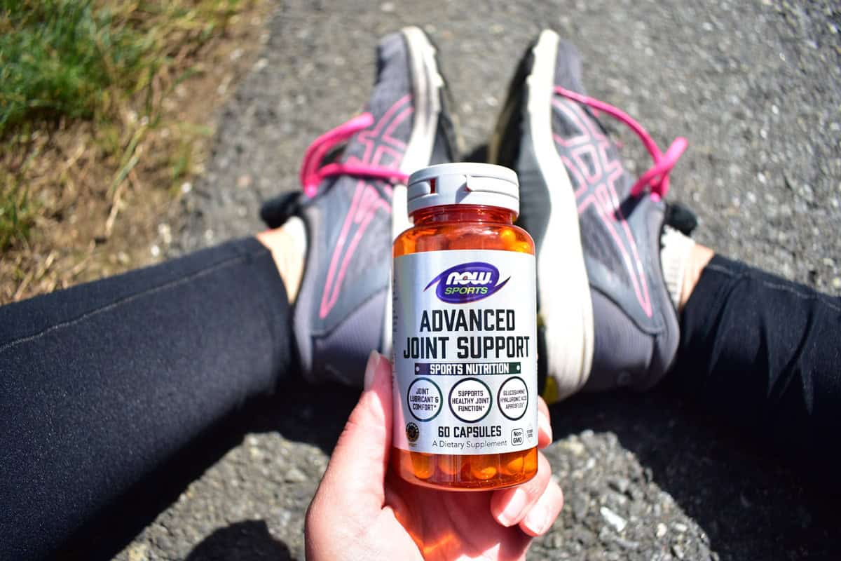 A runner holding a bottle of a joint support supplement.
