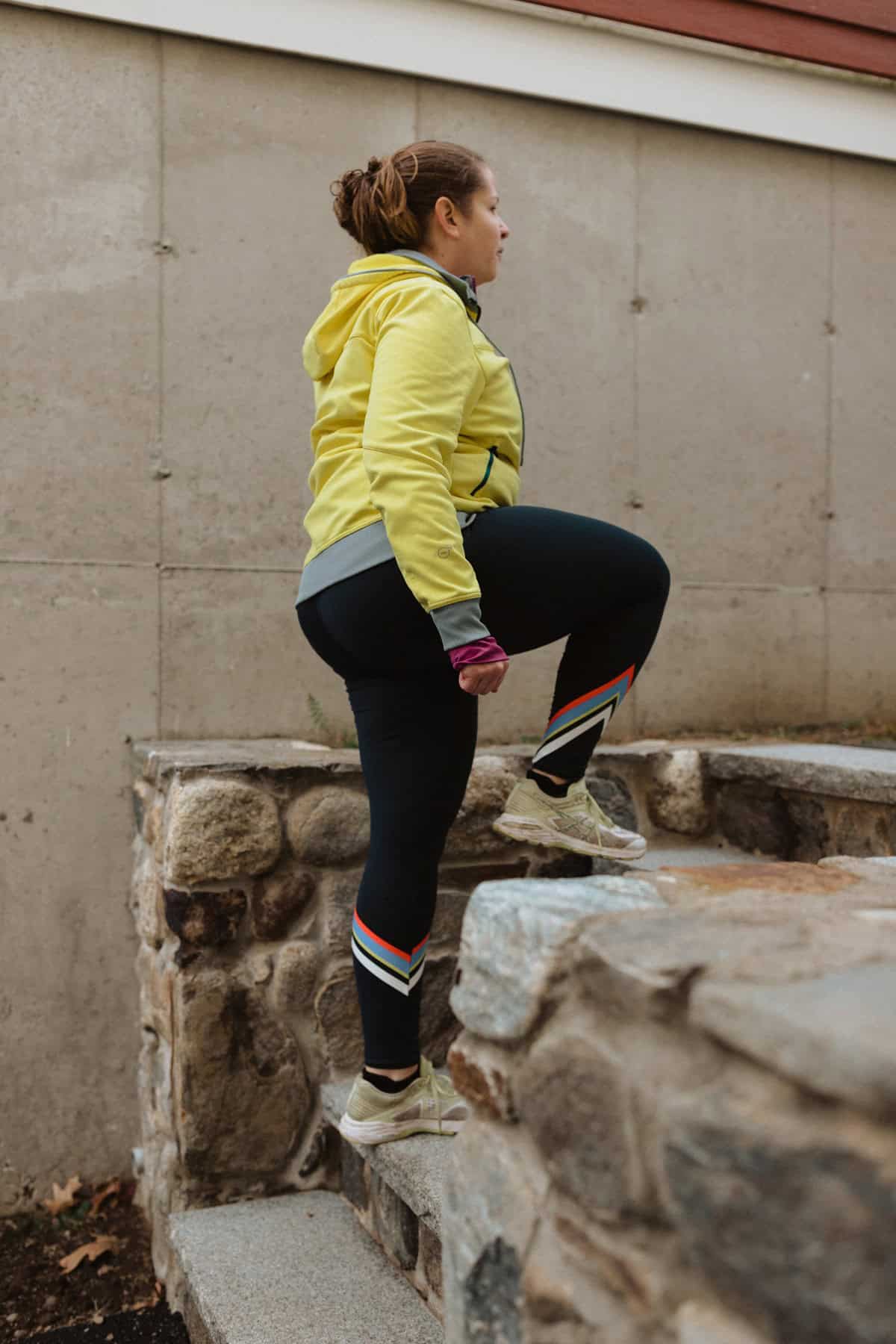 A woman doing step ups outside.