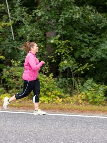 A woman running outside on the road.