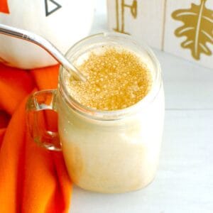 An overhead shot of a protein iced pumpkin spice latte garnished with a sprinkle of pumpkin spice.