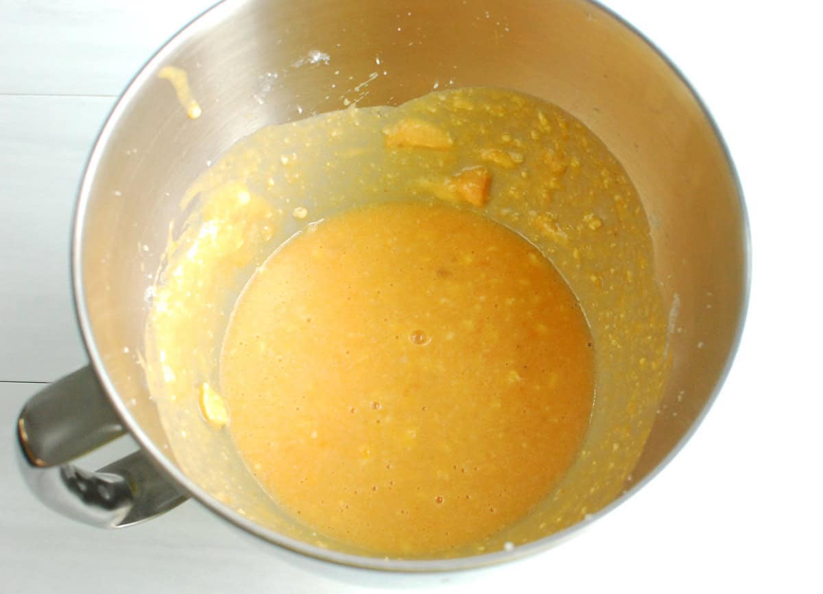 A silver mixing bowl with butter, sugar, eggs, yogurt, vanilla, and pureed sweetpotato mixed together.