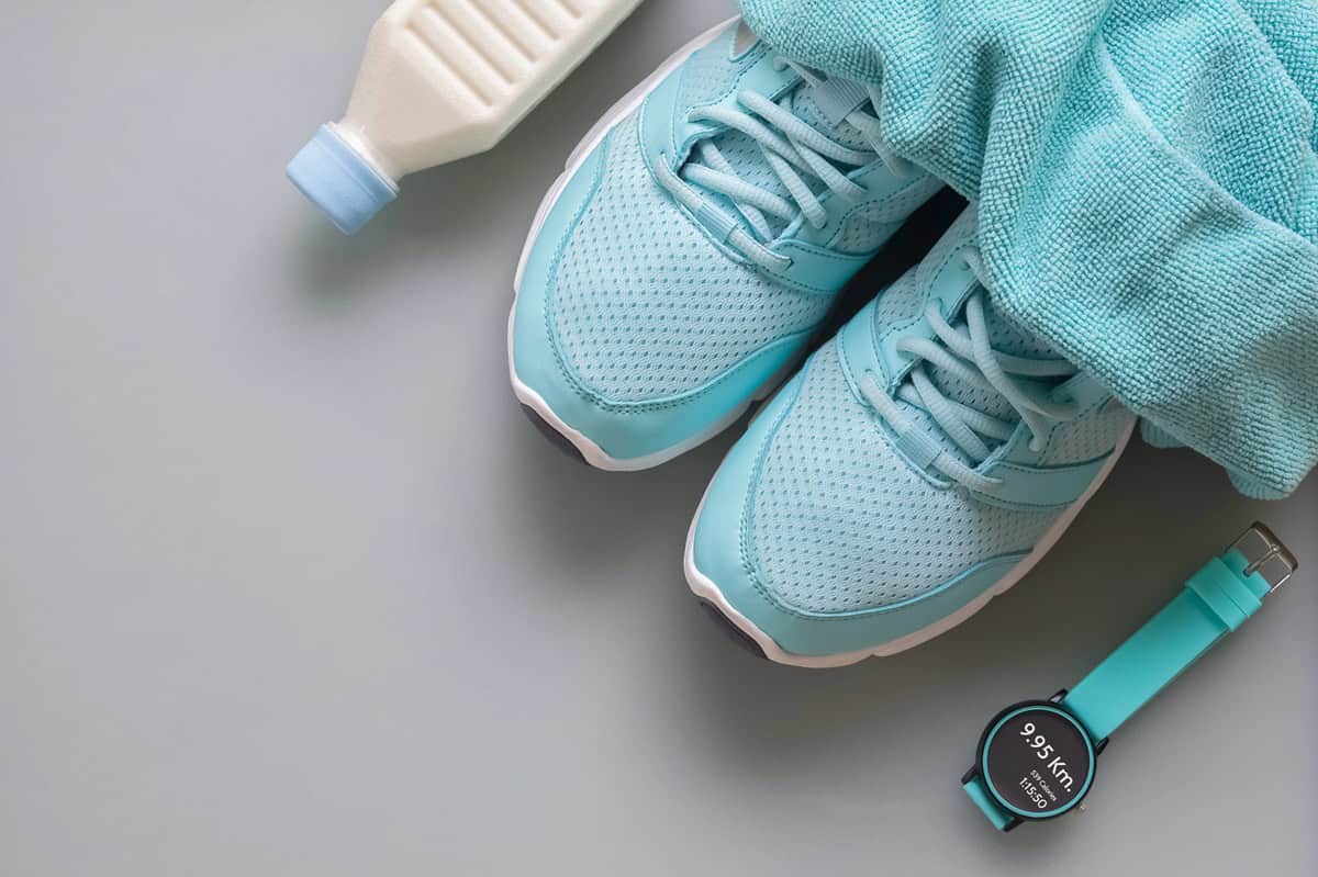 Running sneakers next to a container of milk.
