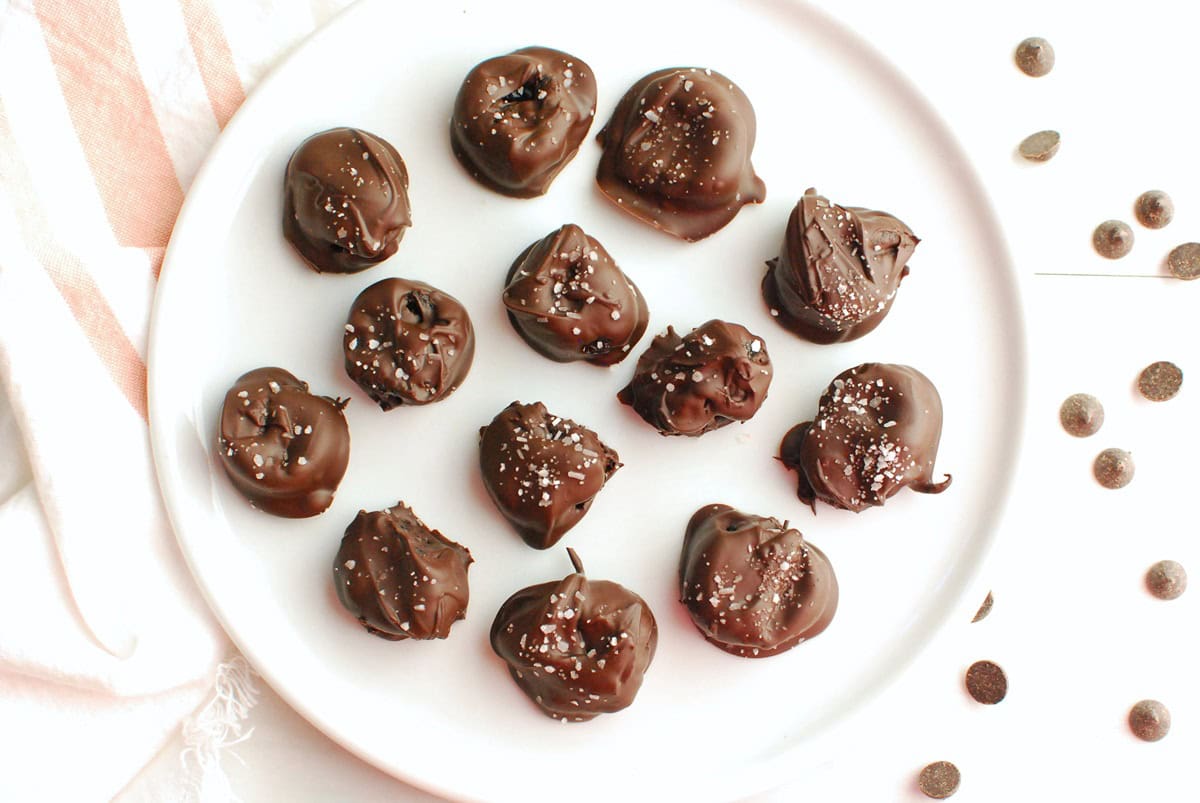 A plate of chocolate covered prunes.