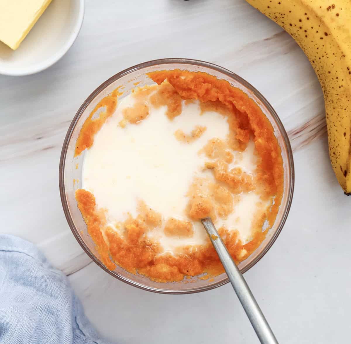 Wet ingredients for the pancake batter mixed together in a glass bowl.