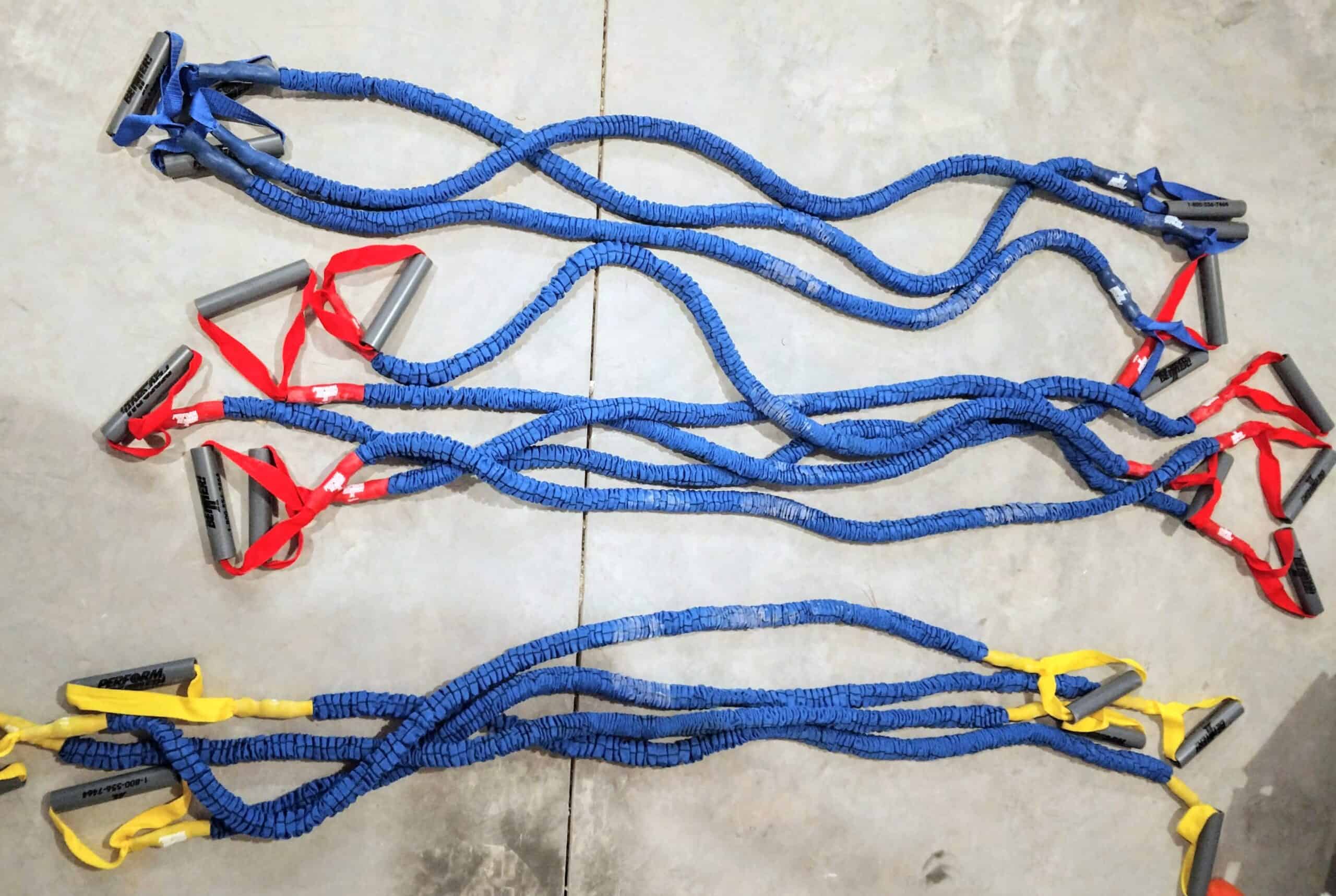 Several different resistance bands on a basement floor.