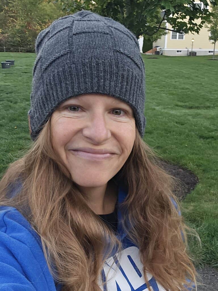 A woman wearing a bluetooth winter hat while walking.
