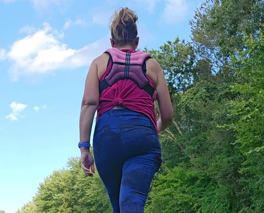 A woman walking in a weighted vest.