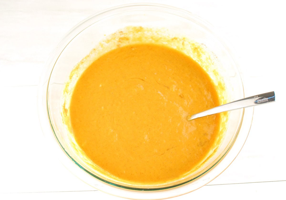 Pumpkin filling mixture in a glass mixing bowl.