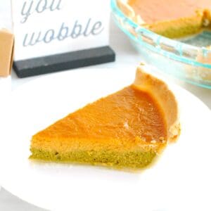 A slice of matcha pumpkin pie on a white plate.