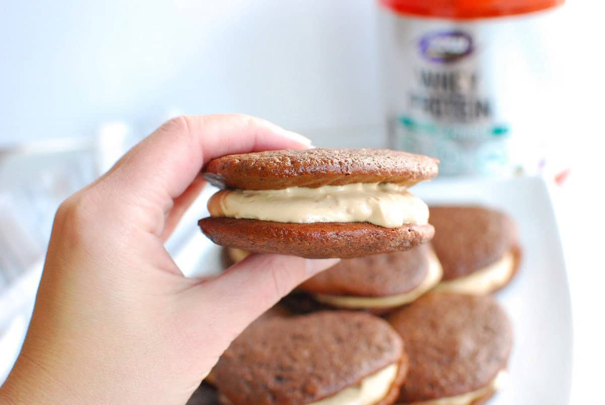 A woman's hand holding a healthy chocolate peanut butter whoopie pie.