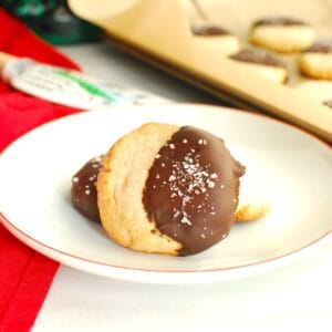 A close up of an almond flour shortbread cookie that was dipped in chocolate and sprinkled with coarse salt.