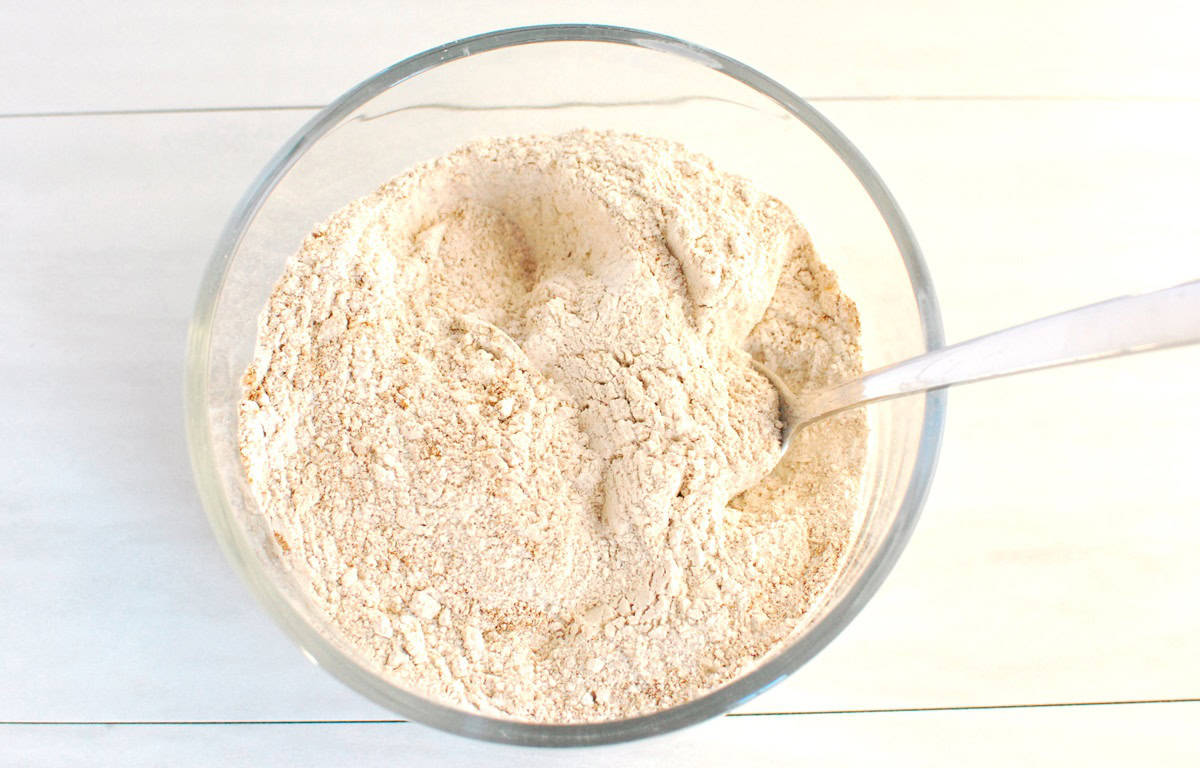 Flour, baking soda, baking powder, cinnamon, ginger, and salt combined in a bowl.