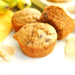 A few ginger banana muffins next to some crystallized ginger and a napkin.