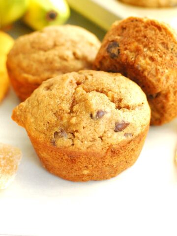 A few ginger banana muffins next to some crystallized ginger and a napkin.
