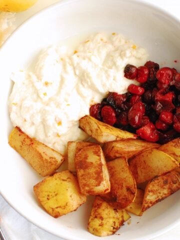 A ricotta breakfast bowl next to a spoon and napkin.