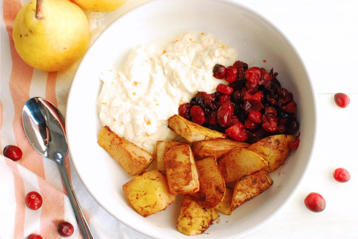A ricotta breakfast bowl next to a spoon and napkin.