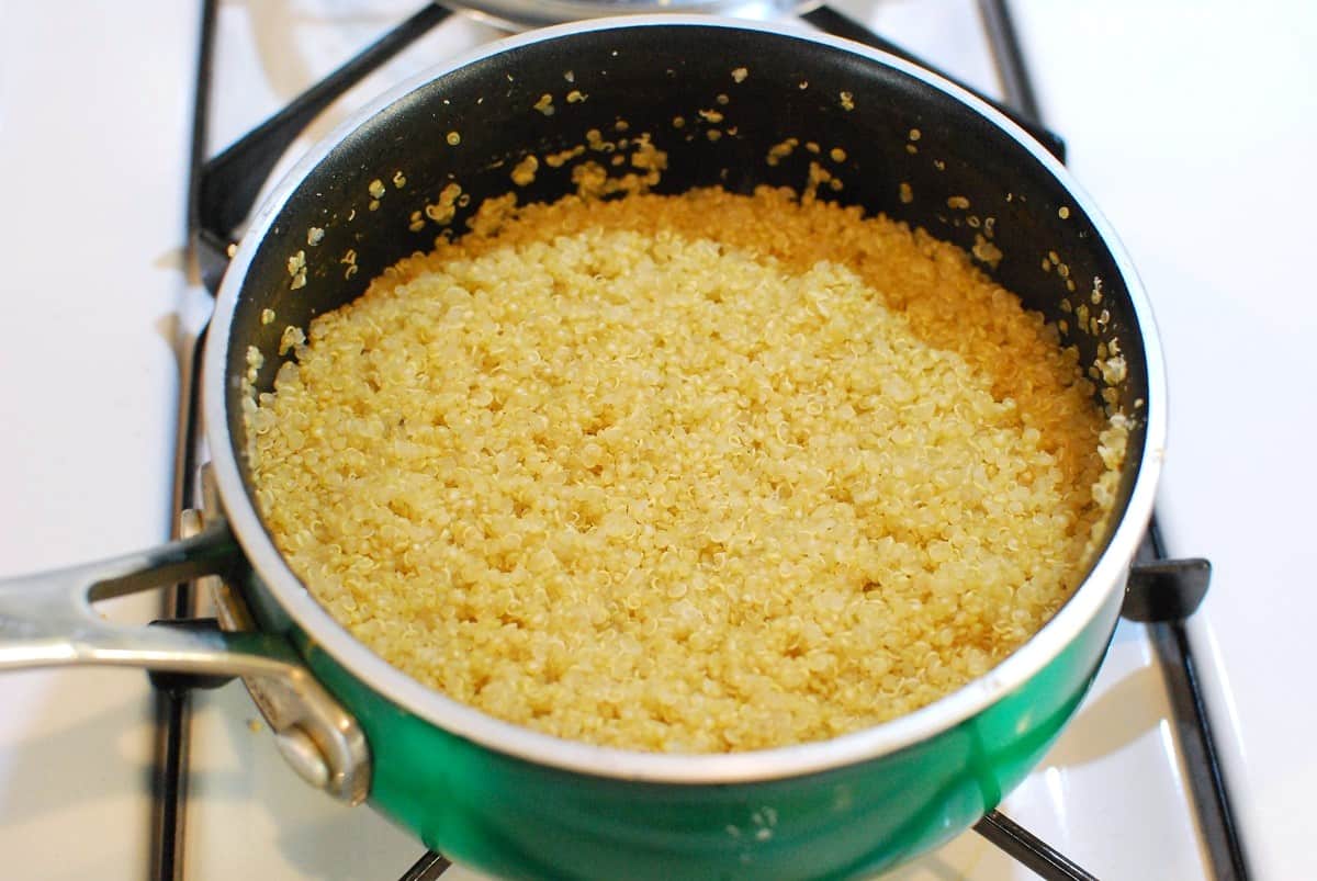 Quinoa cooking in a pot in chicken broth.