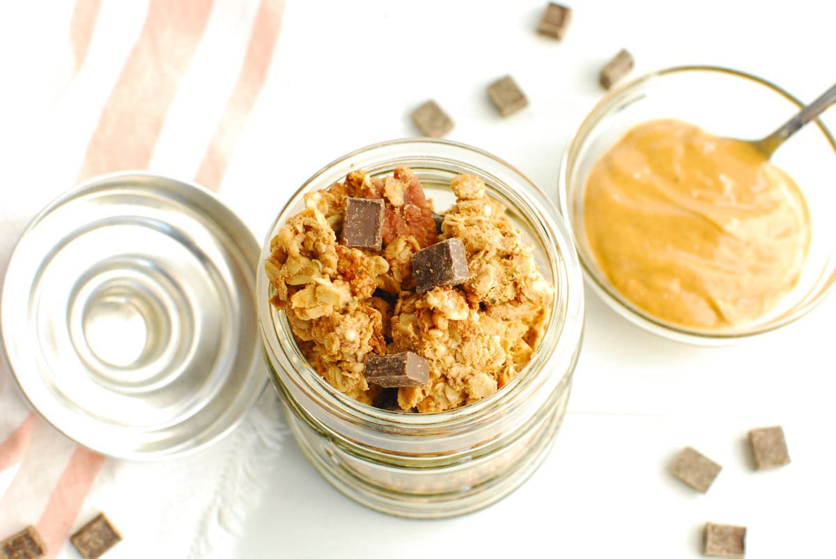 An overhead shot looking at protein granola in a jar, showing the clusters and chunks of chocolate.