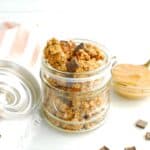 A small glass jar filled with chocolate peanut butter protein granola.