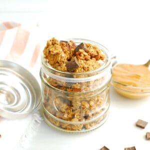 A small glass jar filled with chocolate peanut butter protein granola.