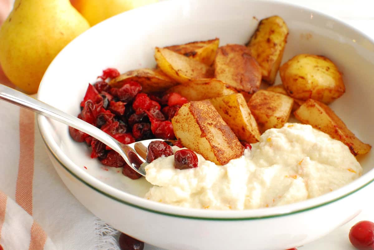 A spoon digging into a ricotta breakfast bowl.