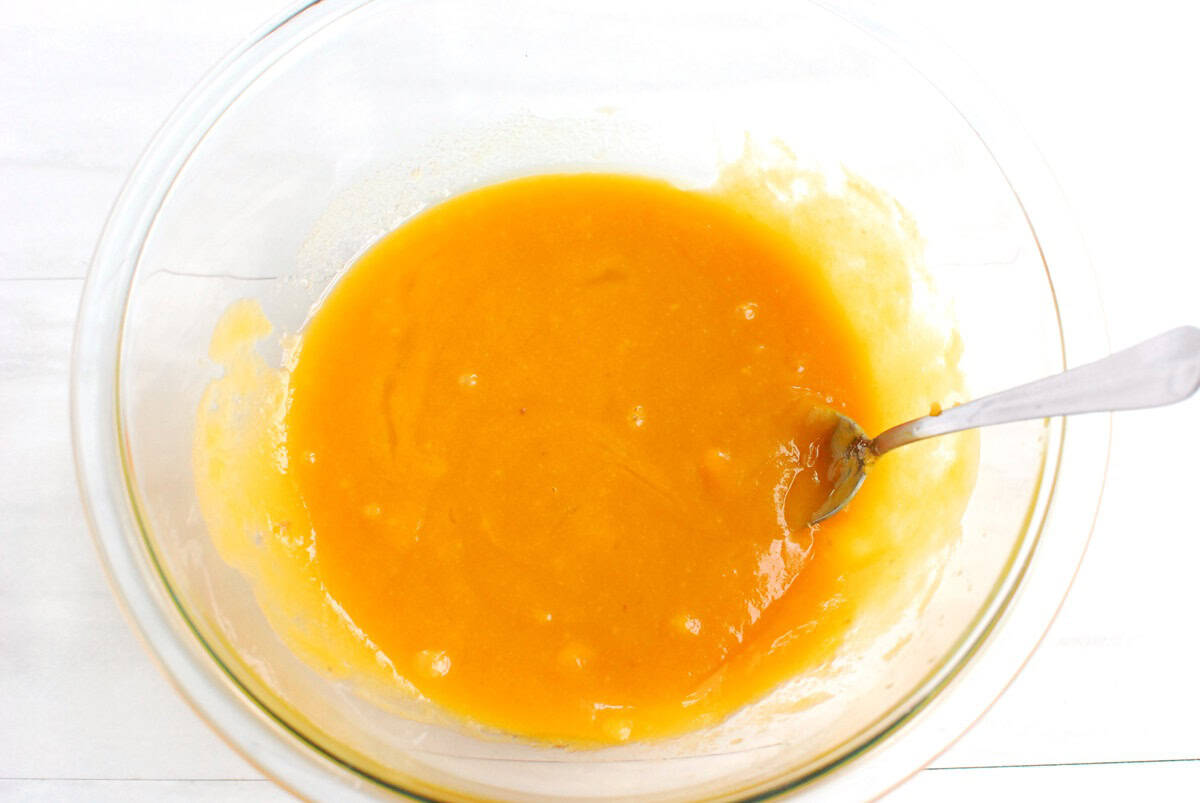 Sweetpotato puree, sugar, oil, egg, and vanilla mixed together in a glass bowl.